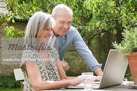 Couple d'âge mûr à l'aide d'ordinateur portable
