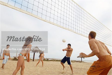 Man Hitting Volleyball during Game on Beach