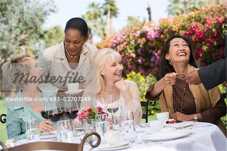 Female friends drinking at outdoor table
