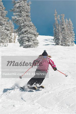 Teenage Girl (16-17) skiing down slope, front view.