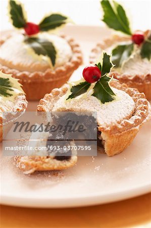 Decorated mince pies on plate, close-up