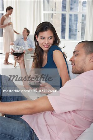 Couples jeunes boire du vin dans le salon