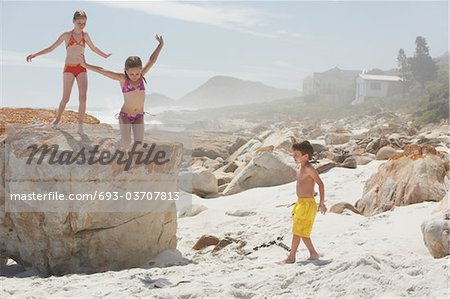 Three Children Playing on Rocky Beach