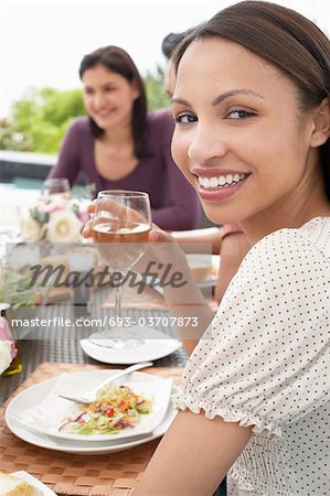 Jeune femme à boire vin lors d'une réception en plein air