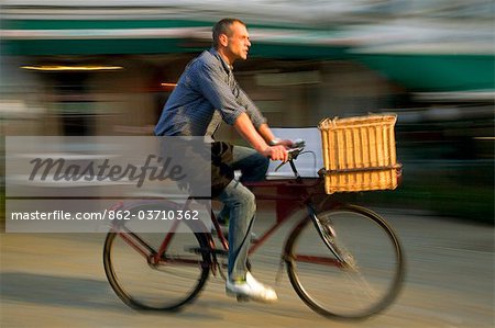 Belgium, Flanders, Antwerp; A man cycling, a common form of transport in the city.