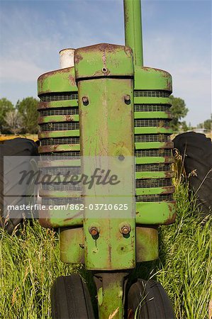 Canada. A green farm tractor in a field on the Canadian Prairie