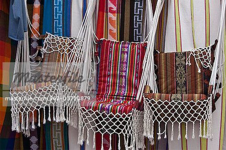 Ecuador, Market stalls selling brightly-coloured, locally-made hanging chairs at Otavalo.