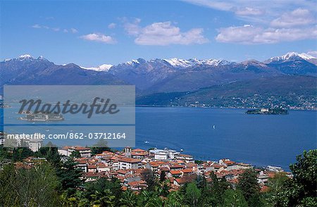View of Lake Maggiore showing typical red roofs and snow capped mountains.