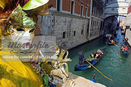 Venice Carnival People in Costumes and Masks on Canal with Gondolas