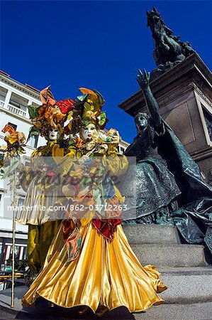 Venice Carnival People in Costumes and Masks infront of Statue