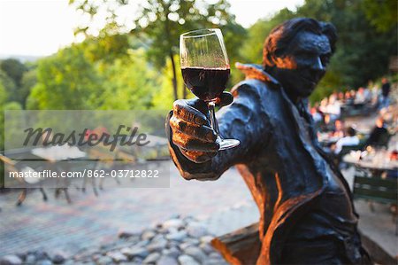Lituanie, Vilnius, Uzupis District, Statue Holding verre de vin rouge au Patio en plein air au Restaurant Tores