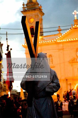 Europe, Malta, Qormi; A caped cross bearer walking barefoot during the Good Friday Processions.
