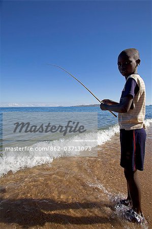 Malawi, Lake Malawi. Likoma Island, on the shores of the lake a young boy tries his hand at fishing