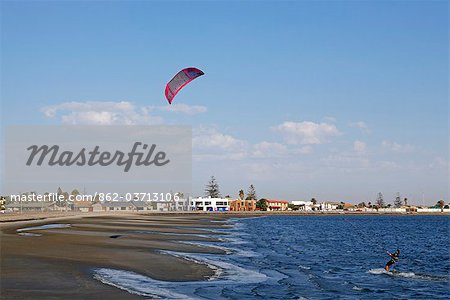 Africa, Namibia, Walvis Bay. Kite surfers catching the strong onshore wind in the bay to the front of the town.
