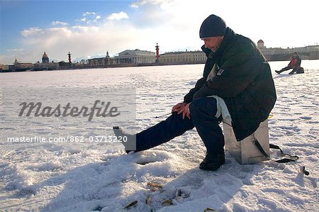 Russie, Saint-Pétersbourg ; Pêcheur sur la rivière Neva gelée pendant l'hiver.