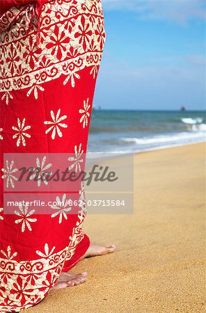 Woman standing on beach, Negombo, Sri Lank.