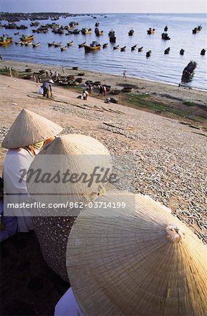 Women sitting next to drying fish, Mui Ne, Vietnam