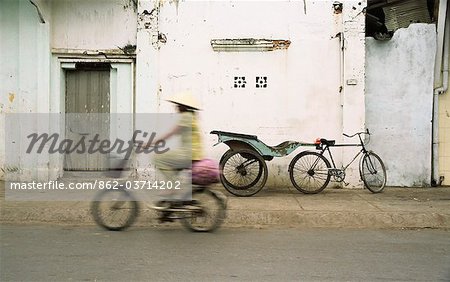 Frau Fahrradfahren entlang der Straße, Ben Tre, Vietnam