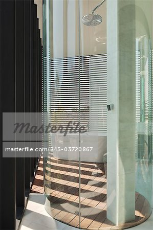 Glass drum shower cubicle in modern bathroom with venetian blinds and patterns of light. Architects: Lim Cheng Kooi and AR43