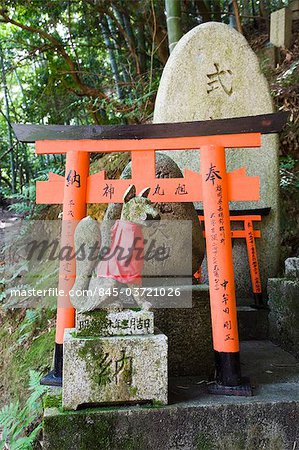 Kitsune or messenger foxes that are a symbol of wealth in Fushimi Inari Shrine, Kyoto, Japan