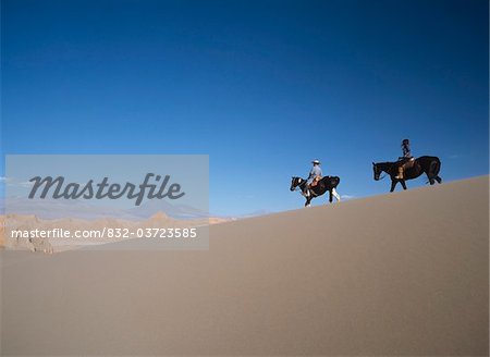 Two people horse riding in Valle de la Muerte