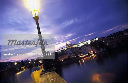 Lampadaire sur le pont Charles et le château de Prague au crépuscule