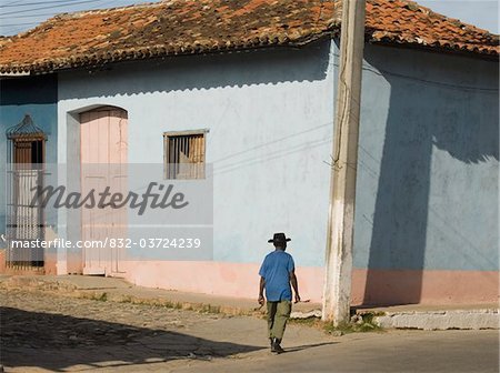 Man walking past colourfully painted houses