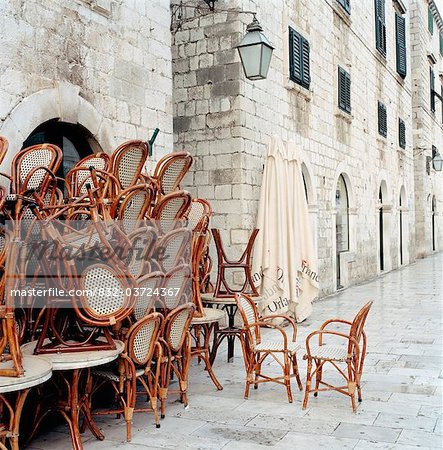 Table and chairs stacked against traditional building