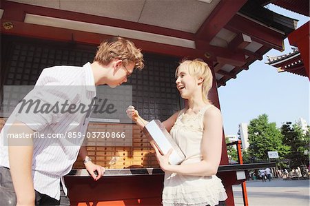 Couple With Fortune Telling Paper In Temple