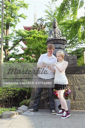 Young Couple Reading Guidebook