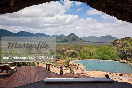 Kenya, A guest enjoying the natural rock swimming pool of Sarara Camp, an ecolodge situated near the Mathews Mountains