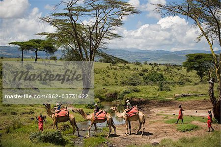 Kenya, Laikipia, Lewa Downs.  Children on a family safari, ride camels at Lewa Downs.
