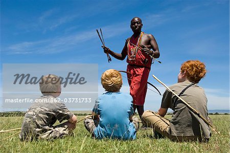 Kenia, Masai Mara. Safari-Führer, Salaash Ole Morompi, zeigt verschiedene Tipps auf seine Pfeile Maasai Boys auf Safari.