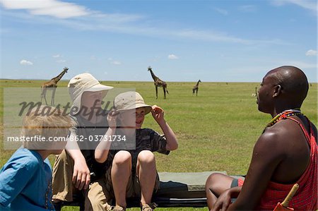 Kenia, Masai Mara. Safari-Führer spricht Salaash Ole mit jungen auf Safari während einer Pirschfahrt heraus in den Plains.