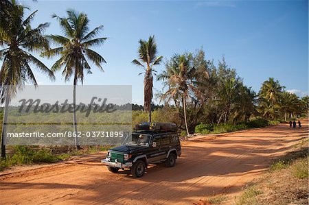 Mozambique, Tofo. A 4x4 drives along the red roads along the coast at Tofo.