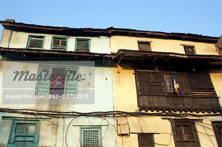 Nepal, Kathmandu, a woman looks out of a window at Swayambunath Temple (Monkey Temple) which overlooks the Kathmandu Valley