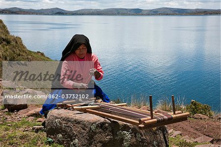 Peru, A Quechua-speaking woman works her traditional wooden loom on Taquile Island.