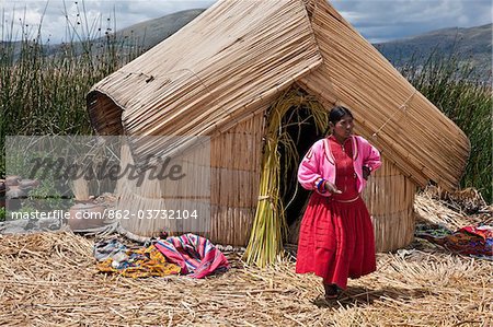 Au Pérou, une fille de Uros en dehors de sa maison sur l'un de l'uniques des îles flottantes du lac Titicaca reed. Au Pérou, une fille de Uros en dehors de sa maison sur l'un de l'uniques des îles flottantes du lac Titicaca reed.