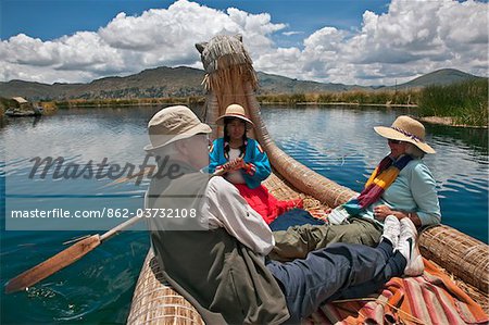 Pérou, touristes en rangs dans une anche traditionnelle en bateau autour de l'uniques des îles flottantes d'Uros sur le lac Titicaca.