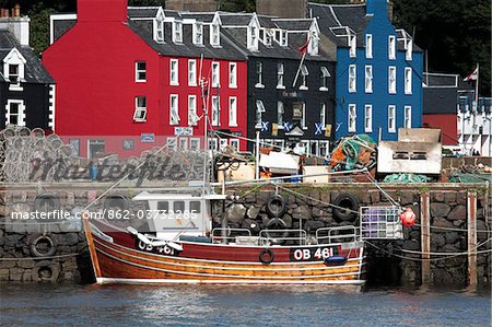 Scotland, Isle of Mull. Fishing boat and colourful waterfront houses at Tobermory harbour.