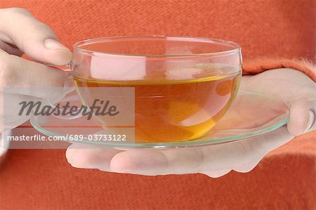 Hand holding cup of Hypericum tea