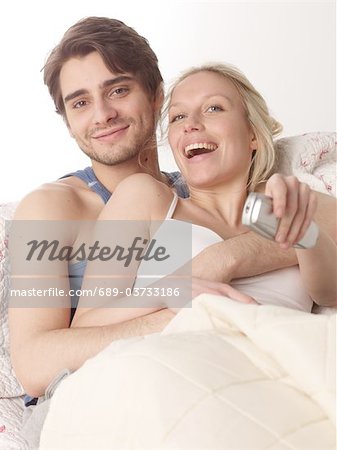 Couple in bed with remote control