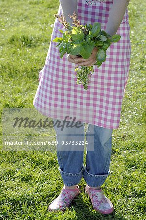 Woman wearing apron holding bunch of flowers