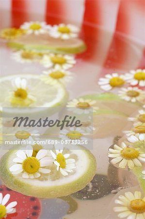 Bath with lemon slices and camomile blossoms