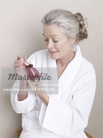 Senior woman holding perfume bottle