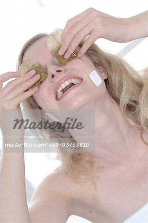 Woman holding teabags in front of her eyes
