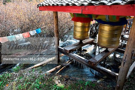 China, Sichuan Province, Jiuzhaigou National Park, Unesco Site, prayer wheels being turned by the flow of river water