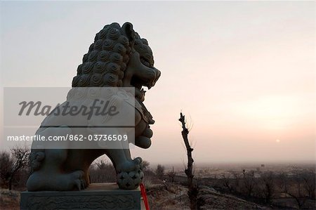 China, Ningxia Province, Baishikou near Yinchuan, lion statue at sunrise