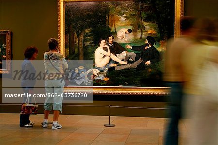 France, Paris. Gens admiratif Manet peinture de Deujeuner sur l herbe dans le Musée d Orsay à Paris.