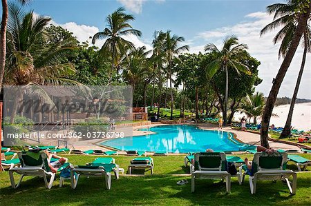 Kenya, Mombasa. La piscine de Baobab Resort avec le sable blanc de Diani Beach à l'arrière-plan.